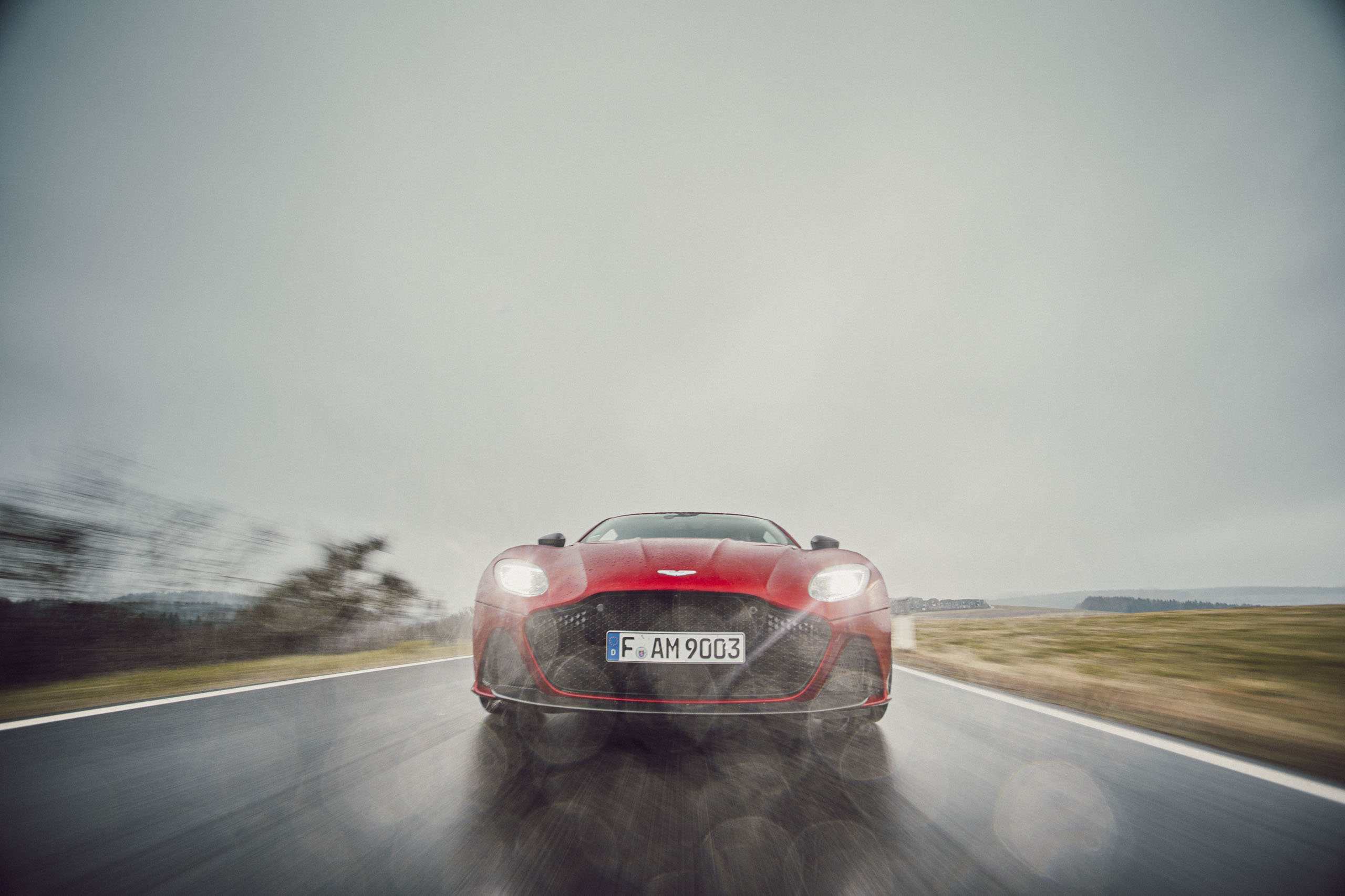 Roter Aston Martin Geneva während Regen bei der Fahrt Front